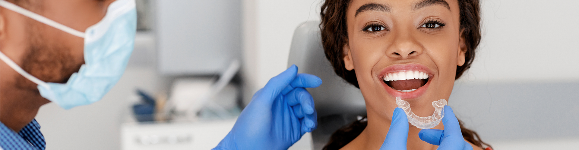 dentist placing clear aligner in patient's mouth
